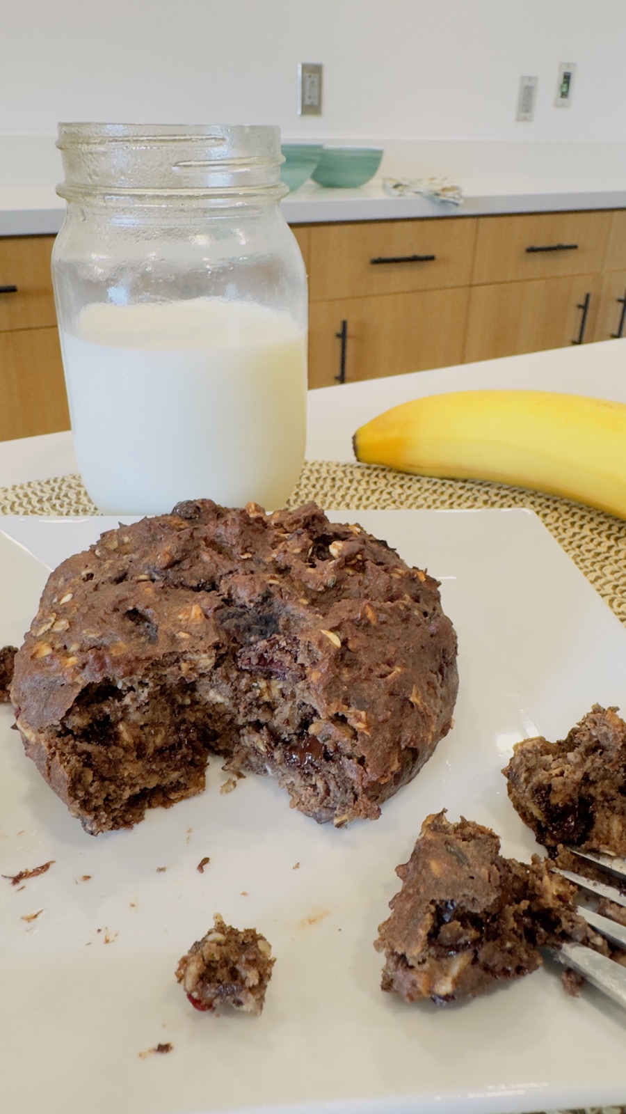 Mason jar of milk beside a broken chocolate cookie
