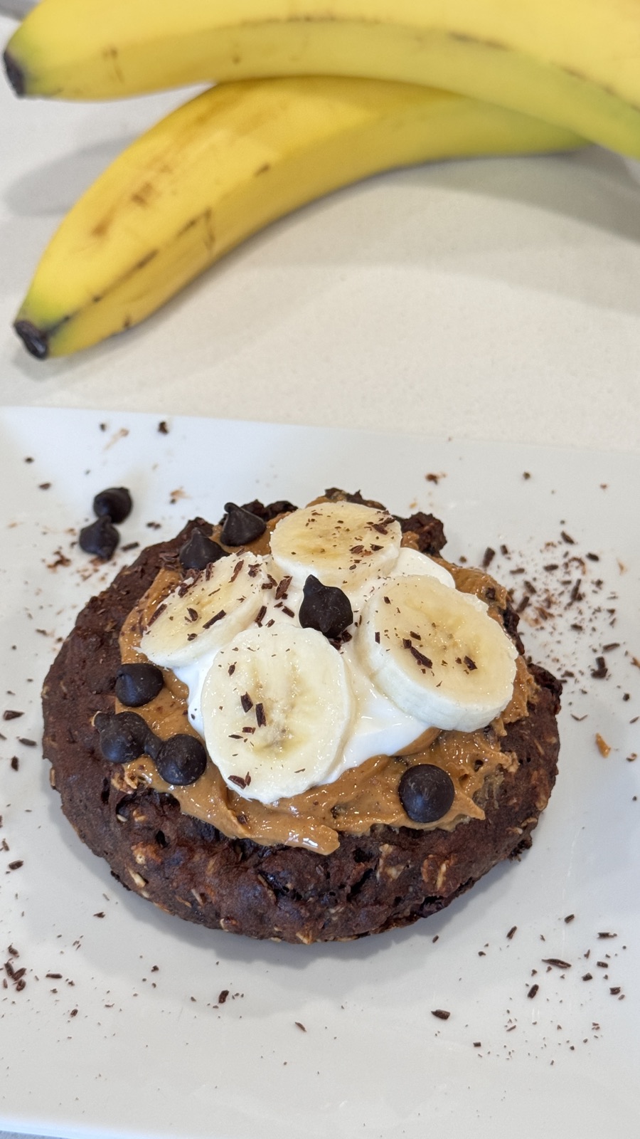 Cookie topped with peanut butter, yogurt, banana coins and chocolate chips
