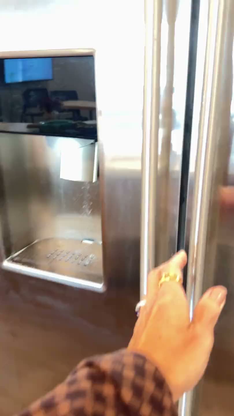 A hand taking a cookie container from a refrigerator shelf
